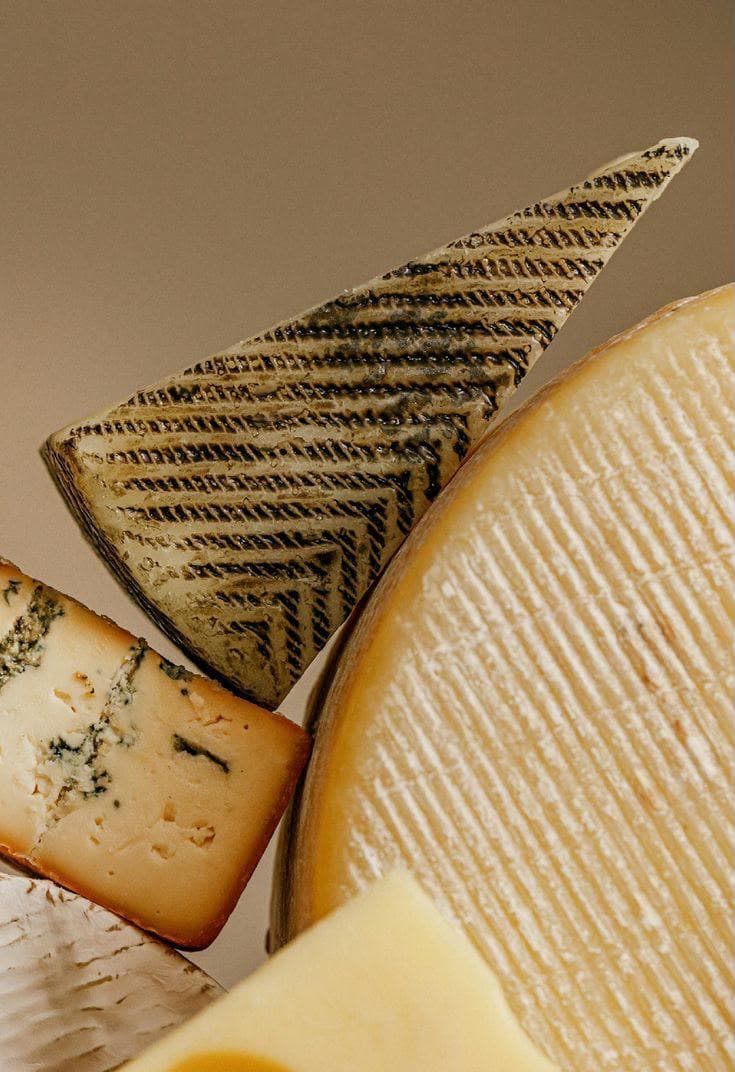 Cuñas de queso curado de distintas variedades, primer plano de texturas de corteza